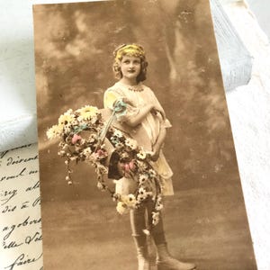 Antike Postkarte, hübsches Mädchen mit Blumen im Korb, weiße Knopfschuhe