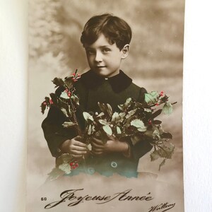 Antike französische Weihnachtspostkarte, ‘Joyeuses Annee’ Kleiner Junge mit Stechpalmenstrauß, echte Fotografie, 1914