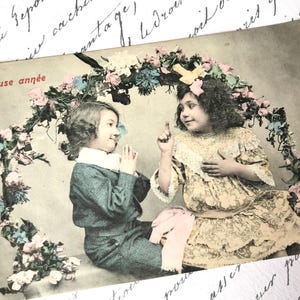 Antike französische Postkarte, hübsches Mädchen im Spitzenkleid, kleiner Junge im eleganten Anzug, Blumenbogen, Bonne Annee