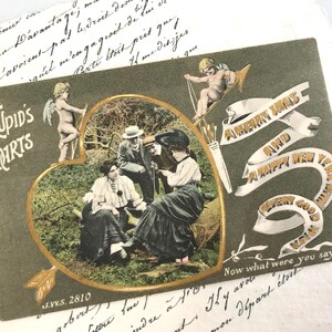 Antike Weihnachtspostkarte, Edwardianische Brautpaar-Liebe, Hübsche Damen, 'Cupid's Darts', handkolorierte Fotografie, Trichromie