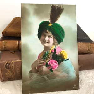 Antike Postkarte, schöne junge Frau, fabelhafter Hut, rosa und gelbe Blumen, lebendige Farben, echtes Foto, handbemaltes Art Deco, 1916