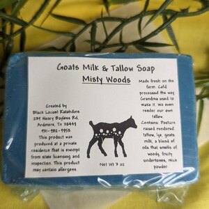 May include: A blue bar of Goats Milk & Tallow Soap by Misty Woods. The soap is made with pasture raised rendered tallow, lye, goats milk, and essential oils. The soap is 3 oz. and is made fresh on the farm. The label also includes the creator's name and address.