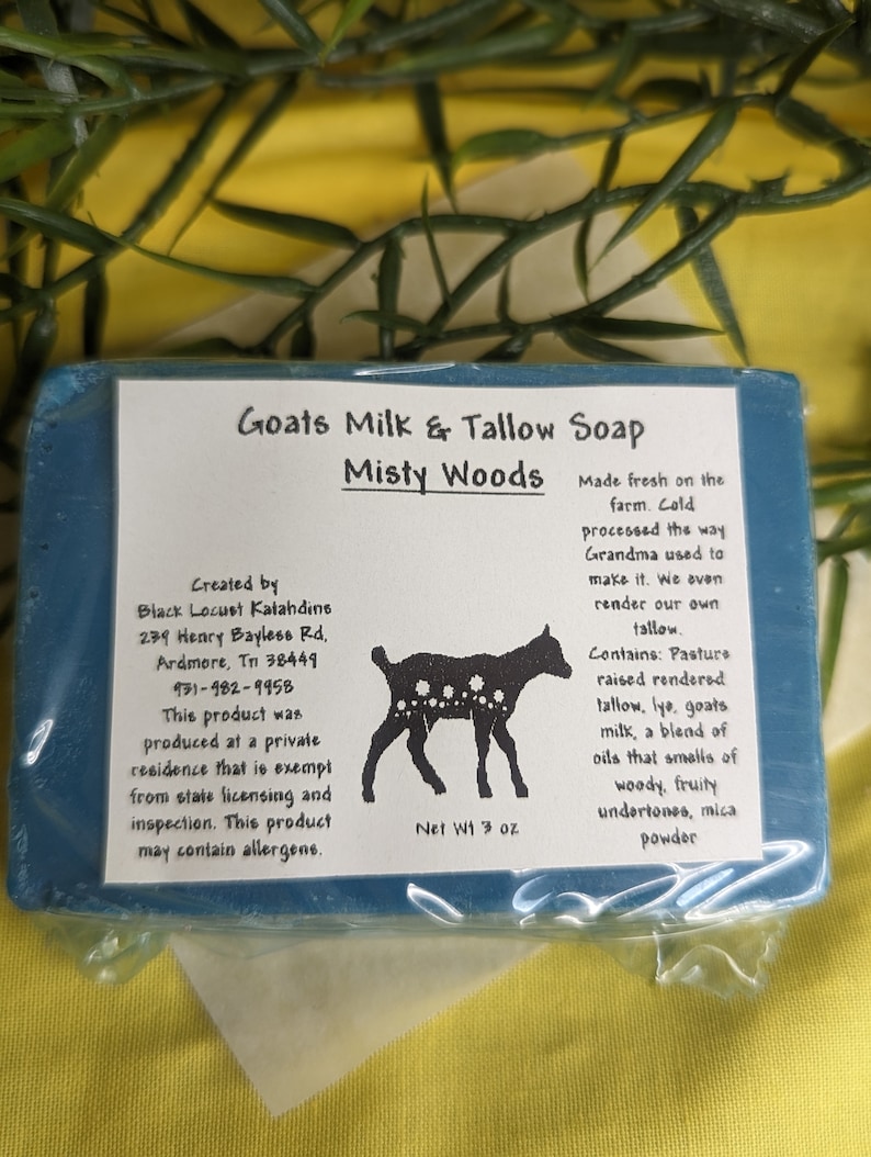 May include: A blue bar of Goats Milk & Tallow Soap by Misty Woods. The soap is made with pasture raised rendered tallow, lye, goats milk, and essential oils. The soap is 3 oz. and is made fresh on the farm. The label also includes the creator's name and address.