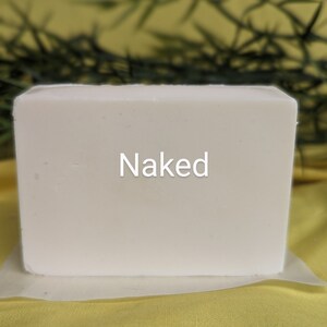 May include: A white bar of soap with the word "Naked" printed on it.