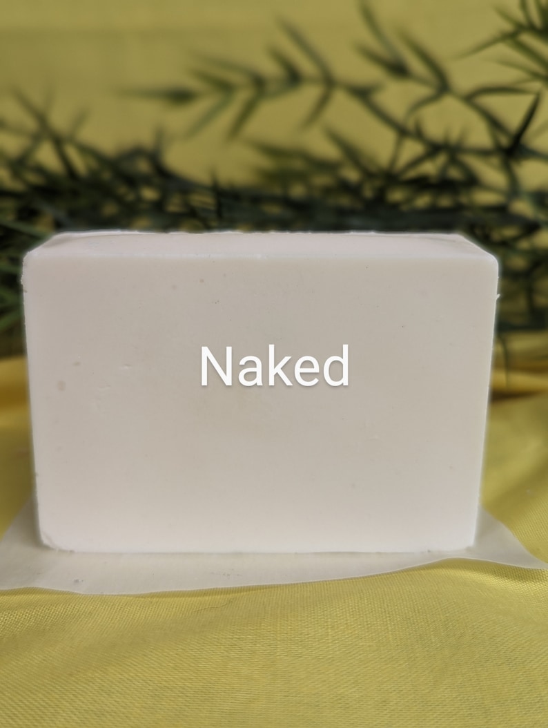 May include: A white bar of soap with the word "Naked" printed on it.