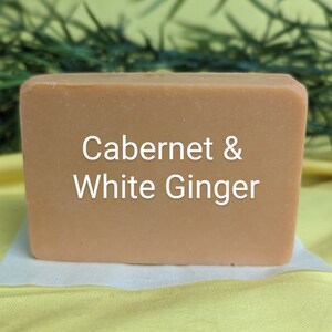 May include: A rectangular bar of soap with a light brown color. The soap has the text "Cabernet & White Ginger" printed on the front.