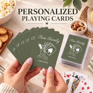 May include: A deck of olive green playing cards featuring the text Ross Family and Game Night with a white line art illustration of a martini glass, playing cards, and dice. The cards are stored in a clear plastic case.
