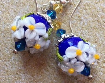 Orecchini pendenti a forma di fiore realizzati a mano con la tecnica del lampwork: vetro blu e cristalli Swarovski - lunghezza 5 cm.