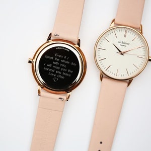 May include: Two rose gold watches with pink leather bands. The watch on the left has an engraved message on the back that reads "Even if I spent the whole day with you, I will miss you the second you leave. Love Glen". The watch on the right has a white face with black markings and the words "architect London" printed on it.