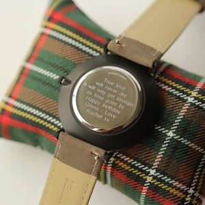 May include: A black watch with a brown leather band. The back of the watch has an engraved message that reads: "True love will never die. It will only get stronger as time goes by. Happy birthday Glenn - Love Rachel xx"