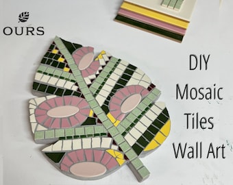 May include: A leaf-shaped mosaic tile art piece with pink, green, white, and dark green tiles. The mosaic is on a gray base. The image also shows a smaller mosaic tile piece and the text "DIY Mosaic Tiles Wall Art."