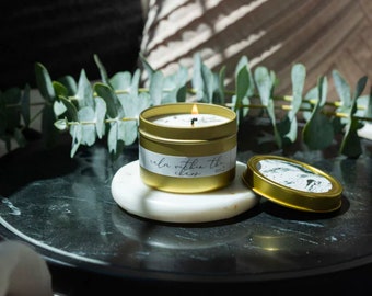 Vela aromática en lata dorada "Calma en el Caos", ideal para aromaterapia o como detalle para regalar.