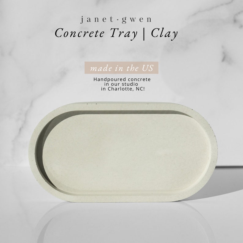 Peut inclure: Un plateau ovale en b&eacute;ton gris clair avec un bord sur&eacute;lev&eacute;. Le plateau est fabriqu&eacute; aux &Eacute;tats-Unis et coul&eacute; &agrave; la main dans un atelier &agrave; Charlotte, Caroline du Nord. Le texte "janet.gwen Concrete Tray | Clay made in the US Handpoured concrete in our studio in Charlotte, NC!" est visible sur l'image.