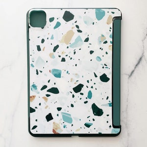 May include: A green and white terrazzo patterned iPad case with a green flap.