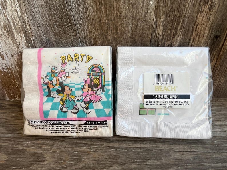 May include: Two packages of paper napkins. One package features Mickey and Minnie Mouse with a jukebox and the word "PARTY". The other package is white with a label that reads "16 BEVERAGE NAPKINS" and measures 9 x 9 inches.