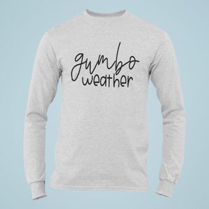 May include: A gray long-sleeve t-shirt with the text "gumbo weather" written in black cursive.