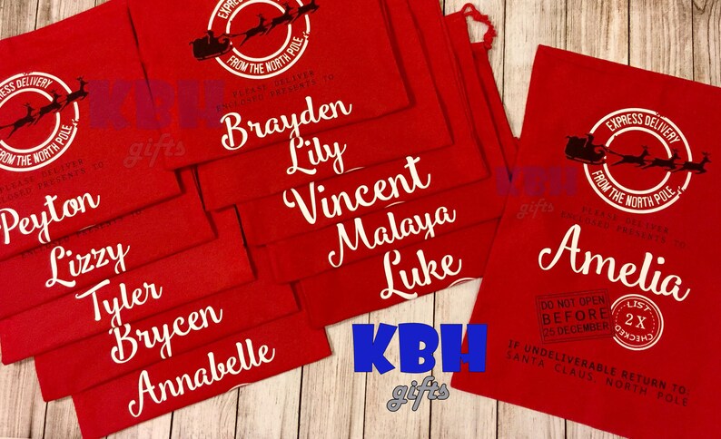 May include: Red fabric gift bags with white lettering. Each bag has a Santa Claus and reindeer graphic with the text "Express Delivery from the North Pole". The bags are personalized with names such as Peyton, Lizzy, Tyler, Brycen, Annabelle, Brayden, Lily, Vincent, Malaya, Luke, and Amelia.