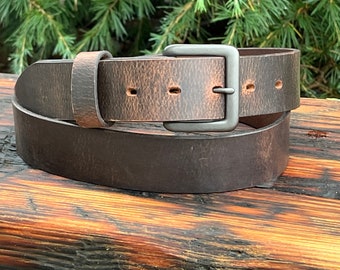 May include: A brown leather belt with a silver buckle. The belt is distressed and has a worn look.