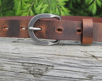 May include: A brown leather belt with a silver buckle. The belt has a distressed look and is made of high-quality leather.