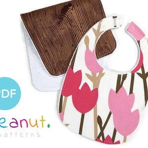 Può includere: Due bavaglini per neonati, uno con un motivo a legno marrone e l'altro con uno sfondo bianco e un design floreale rosa e marrone. I bavaglini sono realizzati in tessuto morbido e assorbente, perfetti per mantenere puliti i vestiti del bambino.