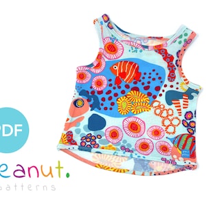 May include: A sleeveless tank top with a colorful print of fish and coral. The print is on a light blue background. The tank top has a scoop neck and a curved hem.