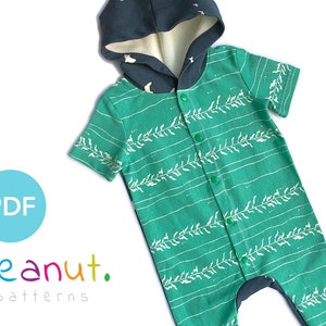 May include: A green and white patterned baby onesie with a dark grey hooded top. The onesie has a row of green buttons down the front.