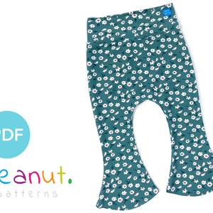 May include: Teal blue bell bottom pants with a white floral print. The pants have a wide waistband and a relaxed fit.