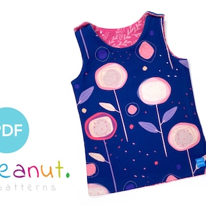 Pode incluir: Um top sem mangas com fundo azul e padrão floral rosa. O top tem um forro rosa e uma pequena etiqueta com o texto "peanut. patterns".