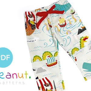May include: White pajama pants with a colorful Viking sea pattern. The pants feature a red drawstring and a repeating design of Viking ships, sea monsters, and waves. The text "Viking Sea!" is also visible.