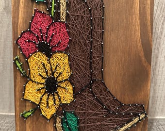Enseigne artistique gansée de bottes et fleurs