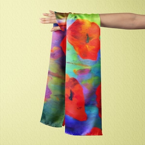 May include: A colorful silk scarf with a watercolor-style design featuring red poppy flowers on a blue, green, and purple background.