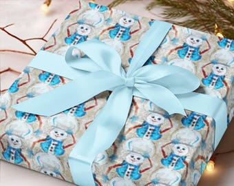 May include: A gift wrapped in brown paper with a blue ribbon. The paper has a repeating pattern of snowmen wearing blue hats and scarves.
