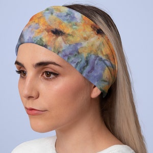 May include: A headband with a floral print featuring yellow, orange, blue, and purple flowers. The headband is made of a soft, stretchy fabric.