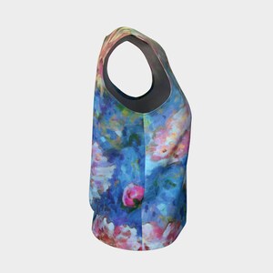 May include: A sleeveless tank top with a floral print featuring pink, blue, and white flowers on a blue background.