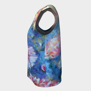 May include: A sleeveless tank top with a colorful floral print on a blue background. The print features pink, white, and yellow flowers.