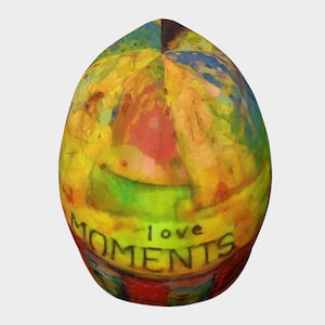 May include: A colourful beanie with a painting of people and the words "love moments" on the front.