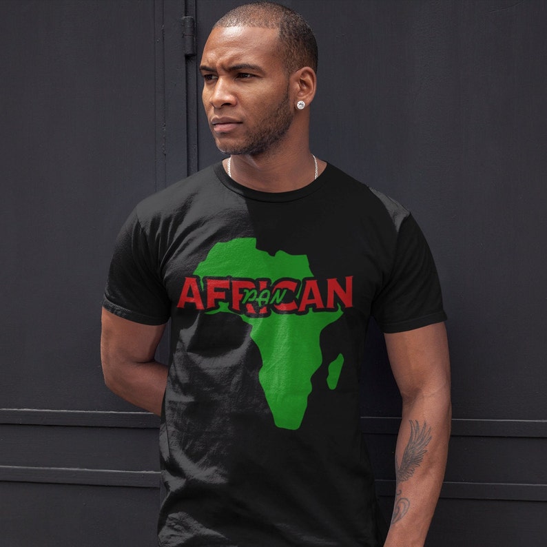 May include: A black t-shirt with a green outline of the continent of Africa. The word "AFRICAN" is written in red letters across the continent, with the word "PAN" in smaller red letters inside the continent.