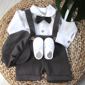 May include: A white linen shirt with a bow tie, brown linen shorts with suspenders, a brown linen cap, and white shoes. This outfit is perfect for a special occasion.