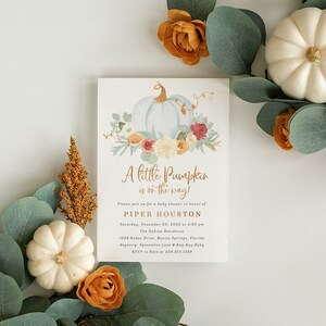 May include: A baby shower invitation with a watercolor illustration of a white pumpkin with fall leaves and flowers. The text reads "A little Pumpkin is on the way!" and includes the name Piper Houston, date, time, and location of the event.