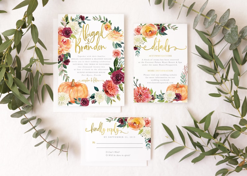Op de afbeelding: Herfstbruiloft-uitnodigingsset met een bloemenkransontwerp met pompoenen, bordeauxrode, perzikkleurige en witte bloemen. De tekst op de uitnodiging luidt "Abigail & Brandon" en bevat details over de bruiloft. De RSVP-kaart bevat de tekst "Graag een antwoord v&oacute;&oacute;r 13 september 2019".
