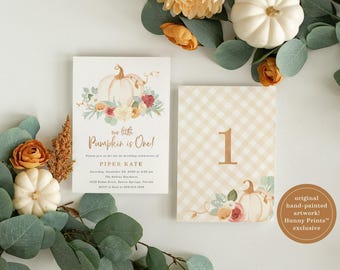 May include: A rectangular birthday invitation and a matching table number card featuring watercolor illustrations of pumpkins, flowers, and eucalyptus leaves. The invitation text reads Our little Pumpkin is One! and the number card displays a large 1.