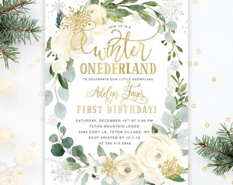 Op de afbeelding: Een rechthoekige uitnodigingskaart met een aquarel bloemenkrans van witte rozen en groene eucalyptusbladeren, geaccentueerd met gouden sneeuwvlokken. De tekst luidt: JOIN US IN A winter ONEDERLAND TO CELEBRATE OUR LITTLE SNOWFLAKE Adelyn Faye's FIRST BIRTHDAY! SATURDAY, DECEMBER 10TH AT 3:00 PM TETON MOUNTAIN LODGE 3385 CODY LN, TETON VILLAGE, WY RSVP KRISTEN BY 12.1.18 AT 239.413.5940