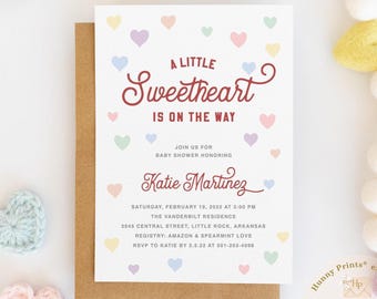 May include: A white rectangular baby shower invitation card with a brown envelope. The card features the text A LITTLE Sweetheart IS ON THE WAY, JOIN US FOR BABY SHOWER HONORING Katie Martinez, and event details, surrounded by small pastel hearts.