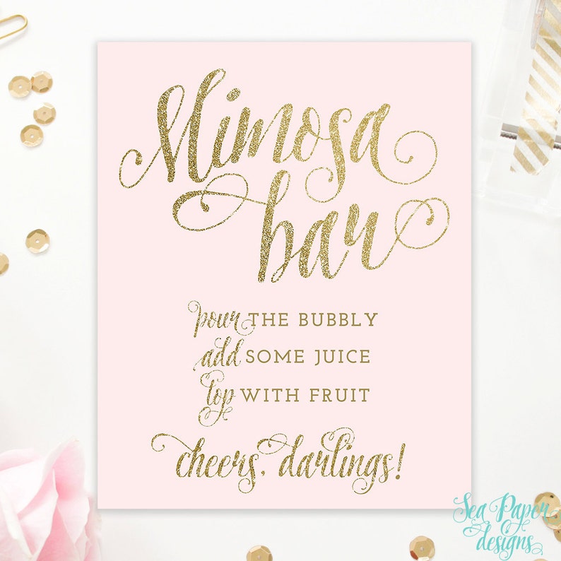 May include: A pink printable sign with gold glitter text that reads "Mimosa Bar" and instructions for making mimosas: "Pour the bubbly, add some juice, top with fruit. Cheers darlings!"