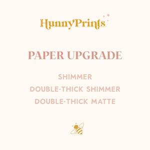 May include: A graphic display featuring the text HunnyPrints in gold, followed by the text PAPER UPGRADE in pink. Below are the options SHIMMER, DOUBLE-THICK SHIMMER, and DOUBLE-THICK MATTE in pink, finished with a small gold bee icon at the bottom.