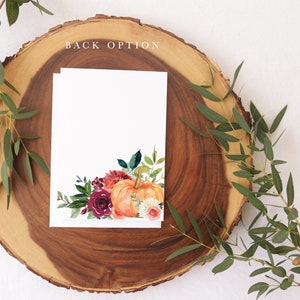 Op de afbeelding: Een witte kaart met een aquarel-illustratie van een pompoen en herfstbloemen. De kaart ligt op een houten schijf met groene bladeren eromheen. De tekst "BACK OPTION" staat bovenaan de afbeelding.