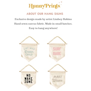 May include: Four canvas hang signs with wooden dowels and beaded hangers. Each sign has a different phrase: "Stay Wild Ocean Child," "Surf Babe," "No Wake Zone," and "Make Waves." The signs are cream-colored with pastel text.