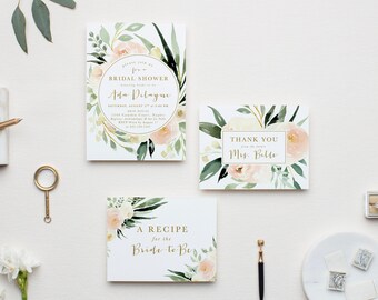 May include: A set of three white paper cards featuring watercolor illustrations of pale pink flowers and dark green leaves. The cards include text for a bridal shower invitation, a thank you note, and a recipe card for the bride-to-be.