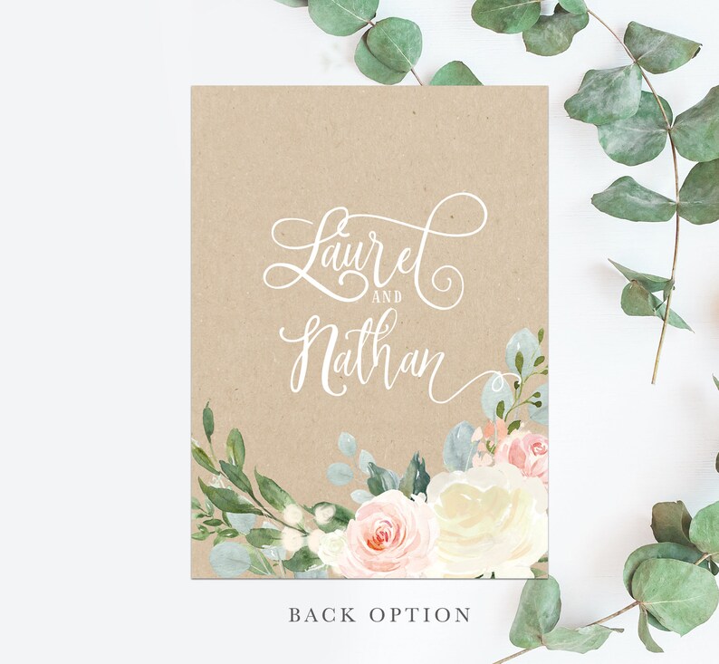 May include: A kraft paper wedding invitation with a floral design. The invitation features a white floral wreath with pink and white roses and green leaves. The text "Laurel and Nathan" is written in white cursive script.