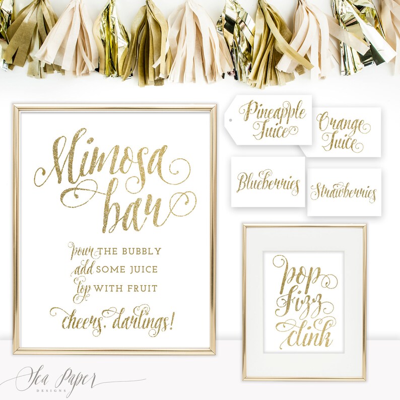 May include: Gold glitter printable signs for a mimosa bar. The signs read "Mimosa Bar", "Pour the bubbly, add some juice, top with fruit, cheers darlings!" and "Pop Fizz Clink". There are also smaller signs that read "Pineapple Juice", "Orange Juice", "Blueberries", and "Strawberries".
